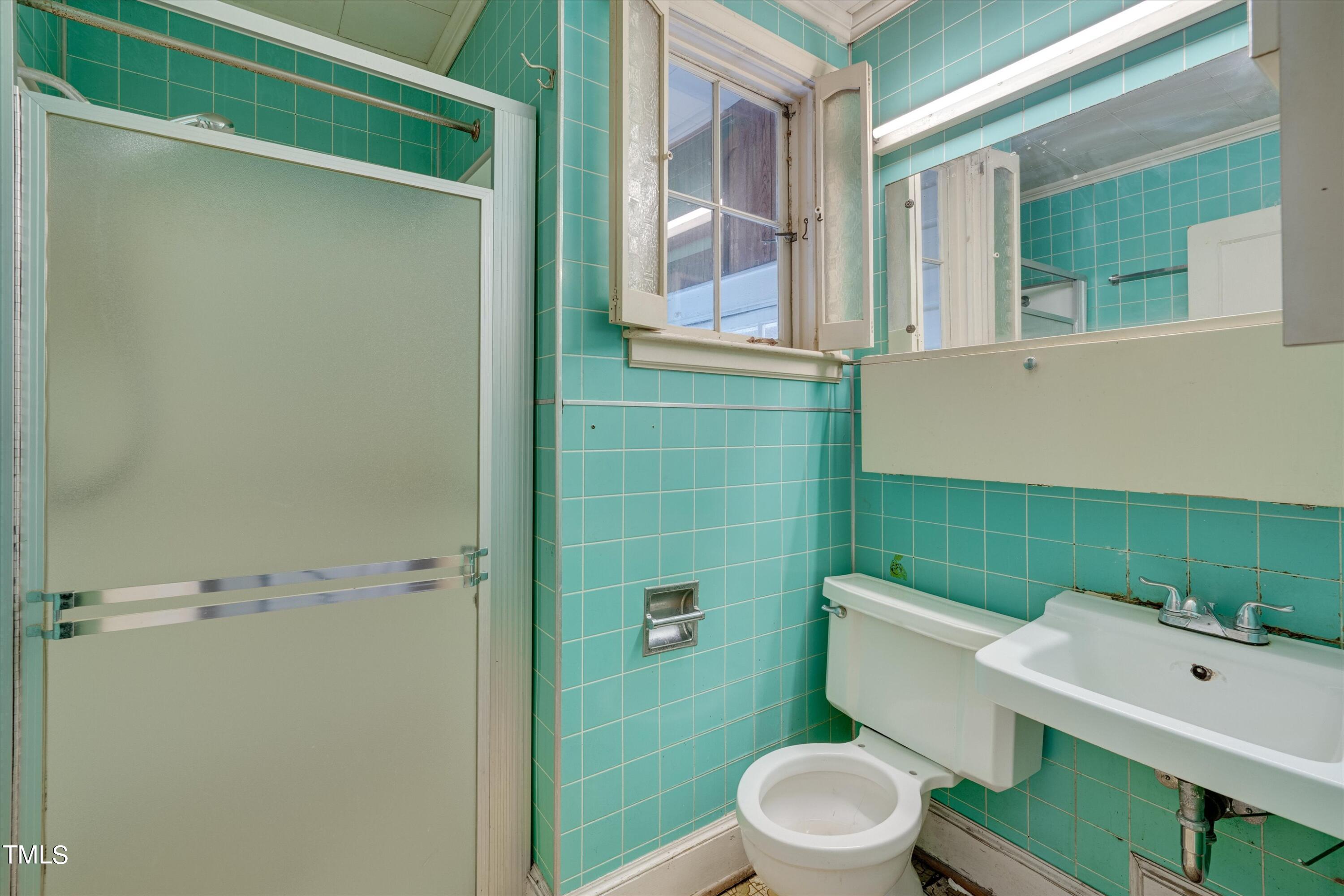 2421 Farthing Street Durham, NC 27704 - Photo 19 of 31 a bathroom with a toilet a sink and mirror
