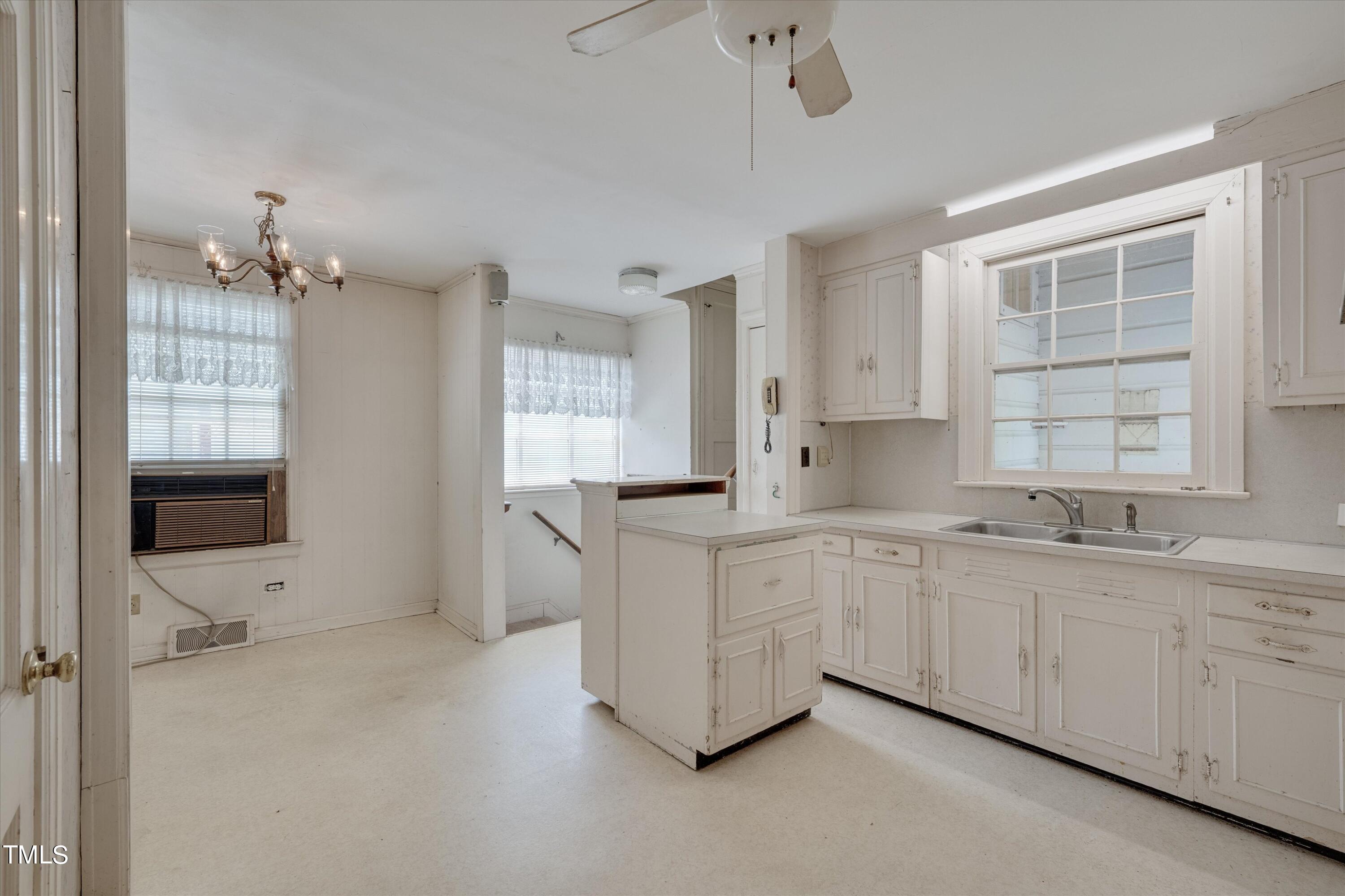 2421 Farthing Street Durham, NC 27704 - Photo 9 of 31 a large white kitchen with a sink and cabinets