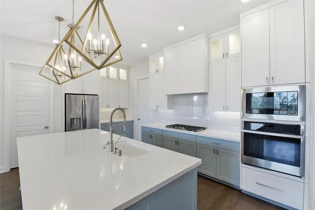 a kitchen with stainless steel appliances a sink a stove and cabinets
