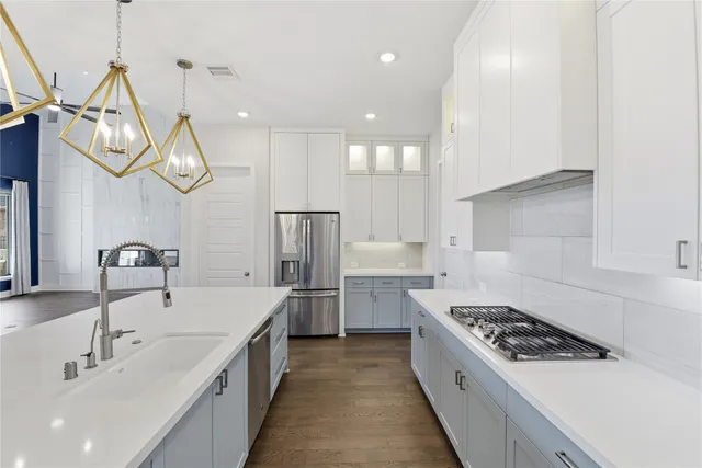 a large kitchen with stainless steel appliances granite countertop a sink a stove and a refrigerator