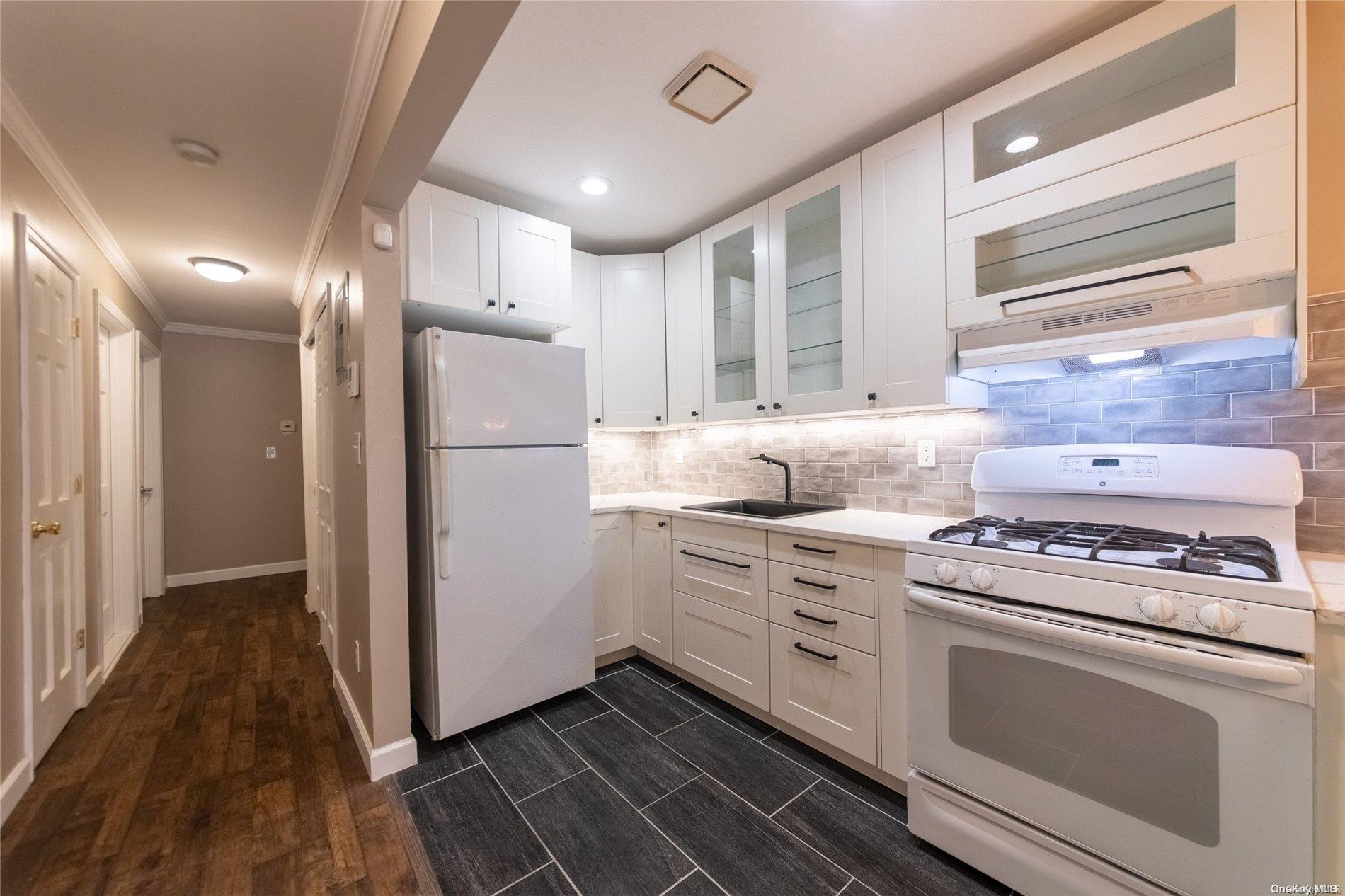334 Lincoln Road Brooklyn, NY 11225 - Photo 6 of 11 a kitchen with a stove microwave and refrigerator