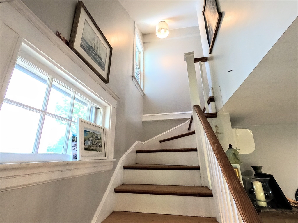 12 Searle Road, Unit 12 Boston, MA 02132 - Photo 9 of 35 a view of staircase with lots of frames on wall and a large window