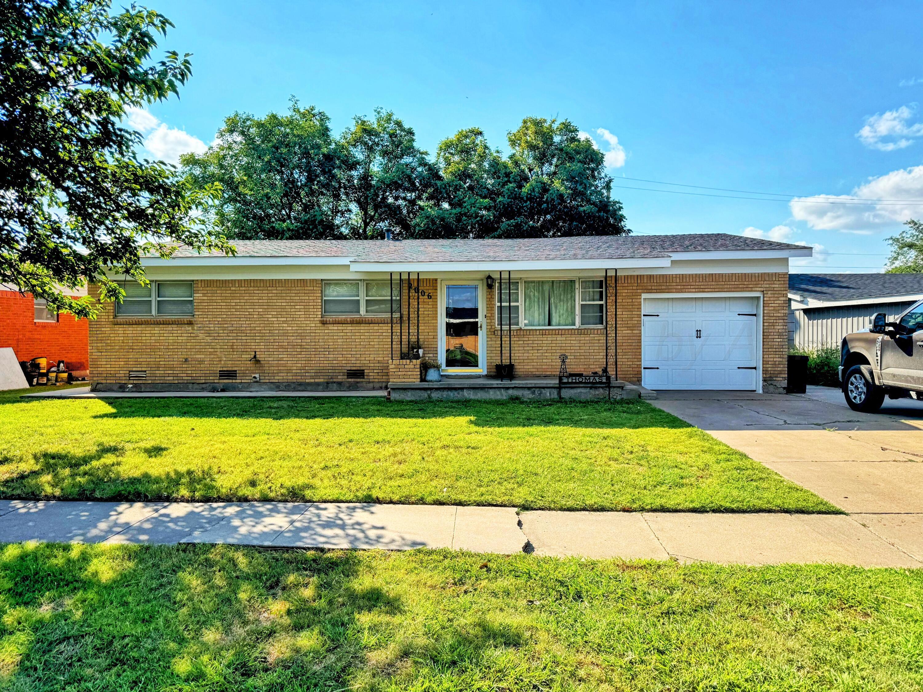 a view of a house with backyard and plants