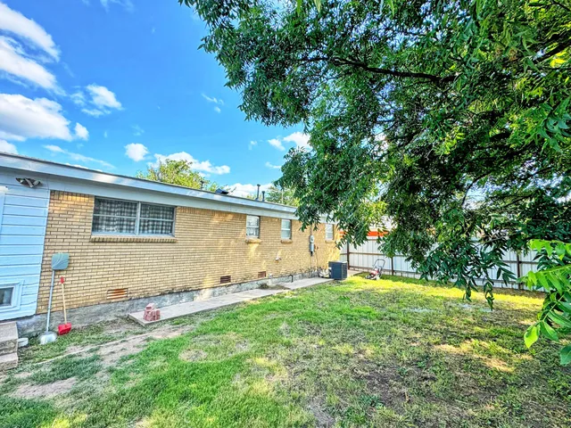 a backyard of a house with table and chairs