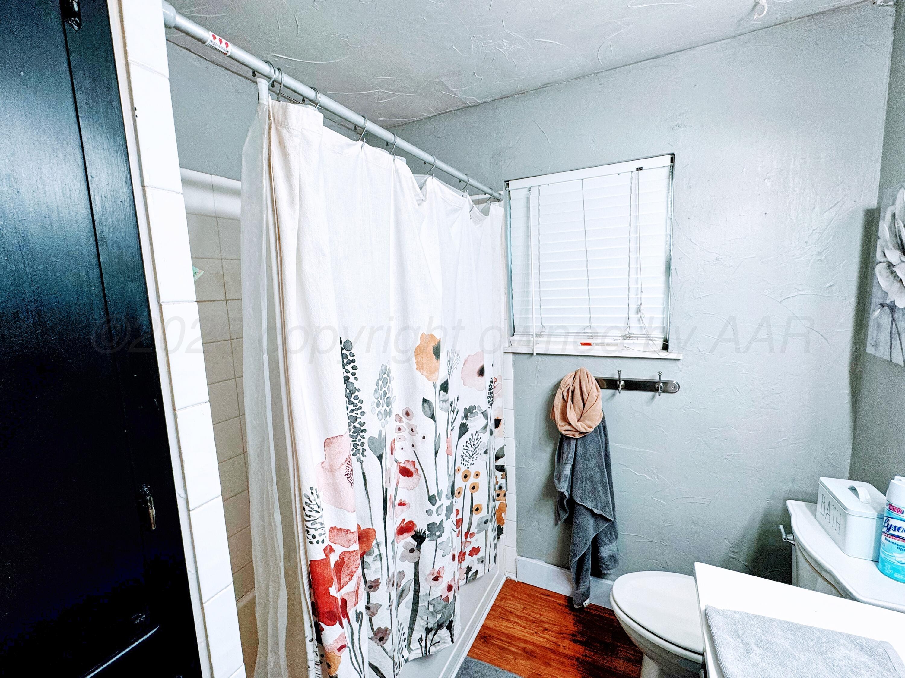 2006 Drake Drive Perryton, TX 79070 - Photo 10 of 17 a bathroom with a window and shower curtain