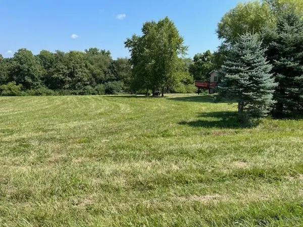 a view of a green field with wooden fence