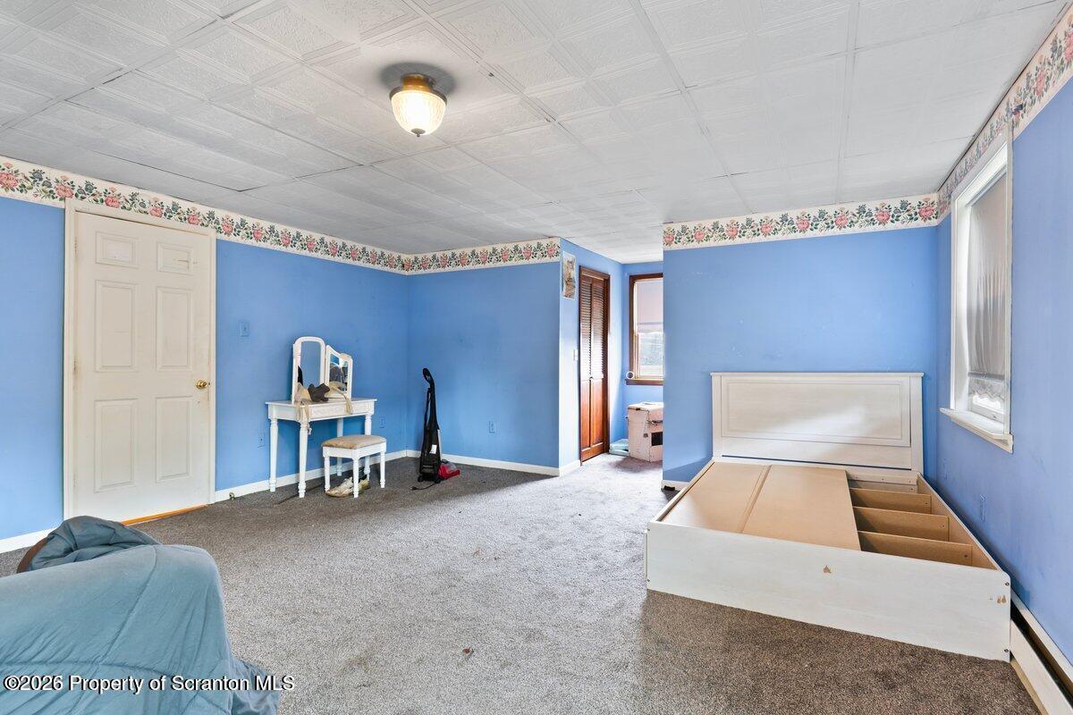 1411 Watson Street Scranton, PA 18504 - Photo 18 of 26 a bedroom with a bed and a chair