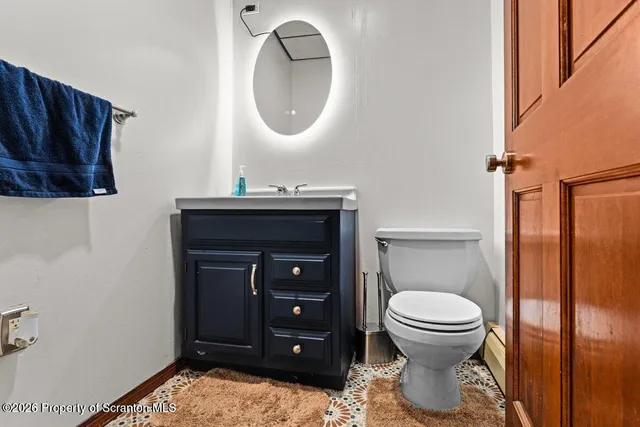 a bathroom with a toilet a sink and mirror
