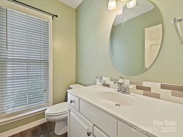 a view of a livingroom with wooden floor and a ceiling fan