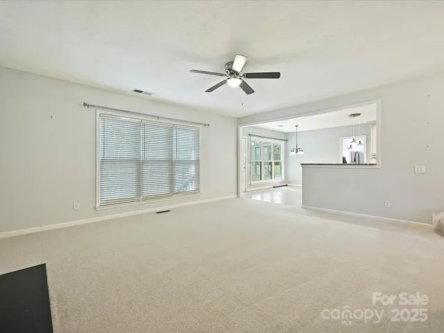 a view of an empty room with a fireplace and a window