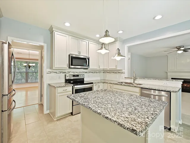 a view of a kitchen with granite countertop a sink and chandelier