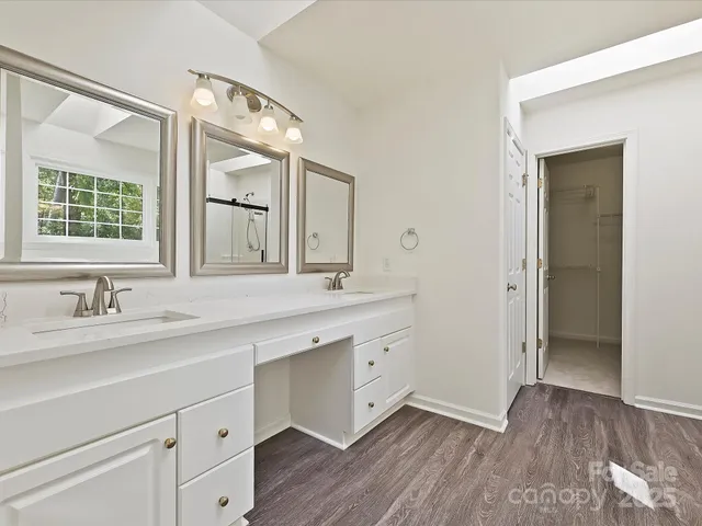 an empty room with windows and chandelier fan
