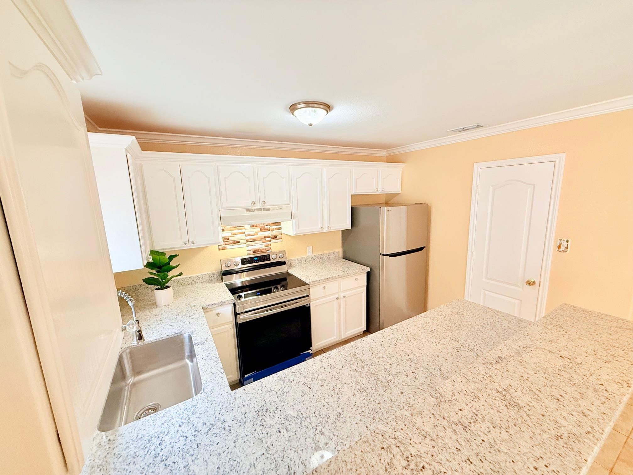 a kitchen with a refrigerator sink and stainless steel appliances