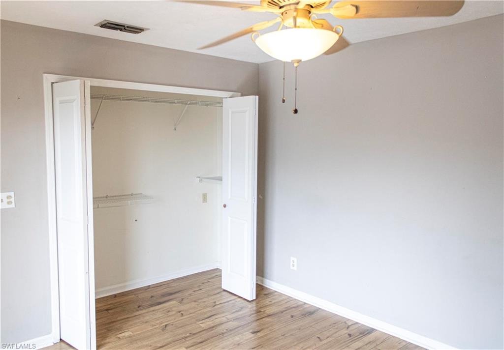 707 Hoover Dike Road Clewiston, FL 33440 - Photo 37 of 39 an empty room with wooden floor and chandelier fan
