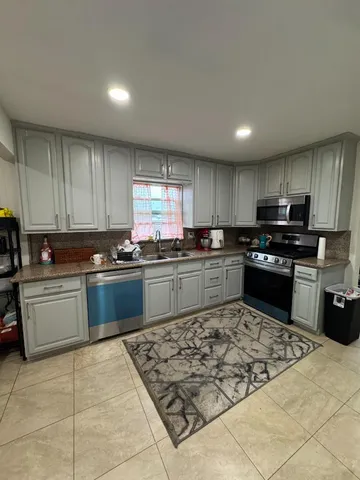 a living room with furniture kitchen area and a window