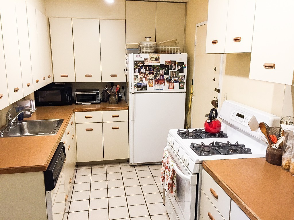 77 Pond Avenue, Unit 606 Brookline, MA 02445 - Photo 11 of 19 a kitchen with a sink a stove and cabinets