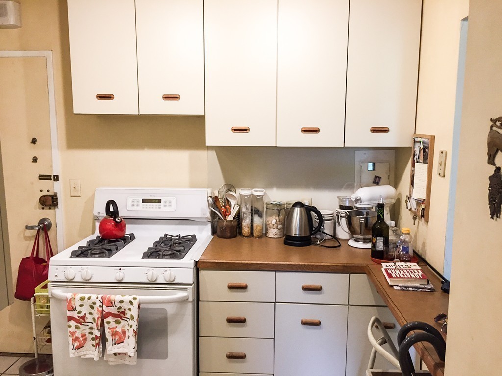 77 Pond Avenue, Unit 606 Brookline, MA 02445 - Photo 12 of 19 a kitchen with a stove and white cabinets
