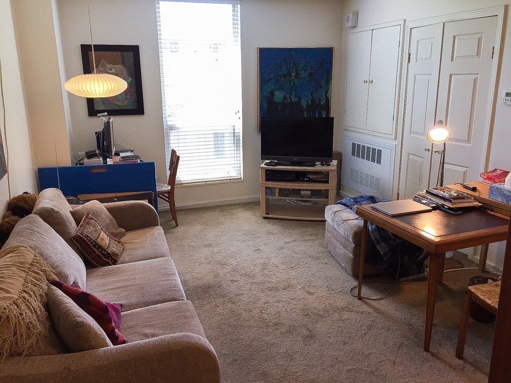77 Pond Avenue, Unit 606 Brookline, MA 02445 - Photo 13 of 19 a living room with furniture and a flat screen tv