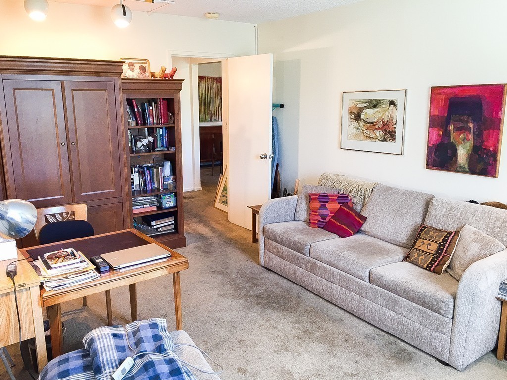 77 Pond Avenue, Unit 606 Brookline, MA 02445 - Photo 14 of 19 a living room with furniture and book shelf