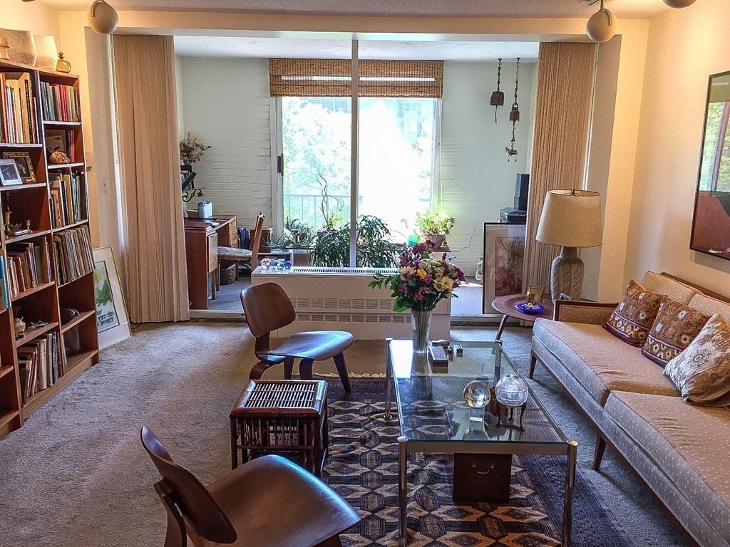 77 Pond Avenue, Unit 606 Brookline, MA 02445 - Photo 3 of 19 a living room with furniture a bookshelf and a window
