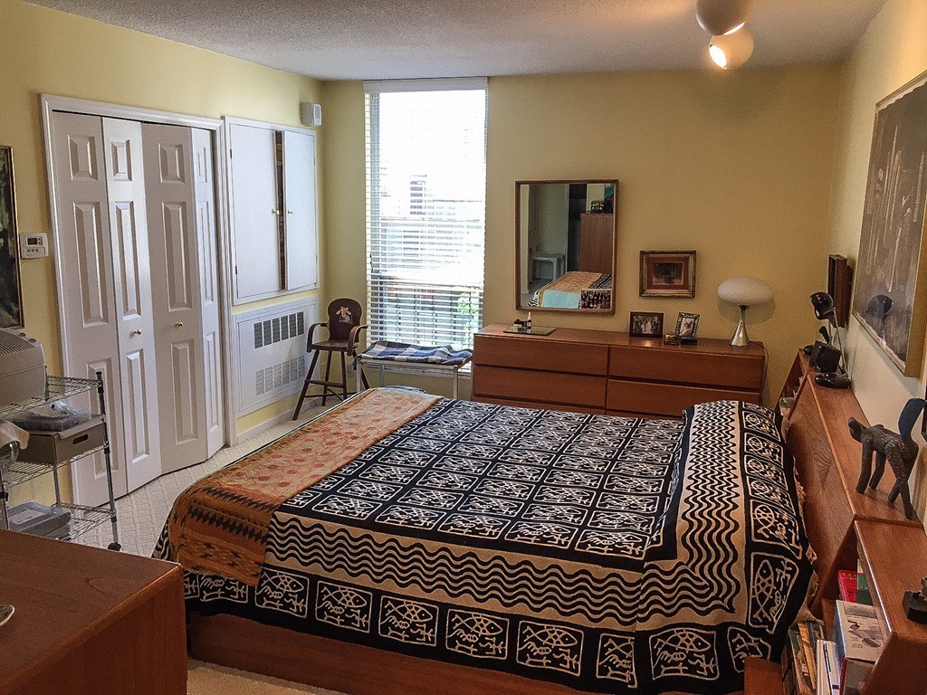 77 Pond Avenue, Unit 606 Brookline, MA 02445 - Photo 6 of 19 a bed sitting in a bedroom and chair next to a window