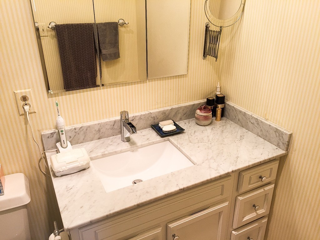 77 Pond Avenue, Unit 606 Brookline, MA 02445 - Photo 8 of 19 a bathroom with a granite countertop sink and a mirror