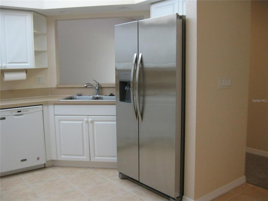 6405 Bay Cedar Lane, Unit 26 Bradenton, FL 34203 - Photo 4 of 19 a kitchen with cabinets and stainless steel appliances