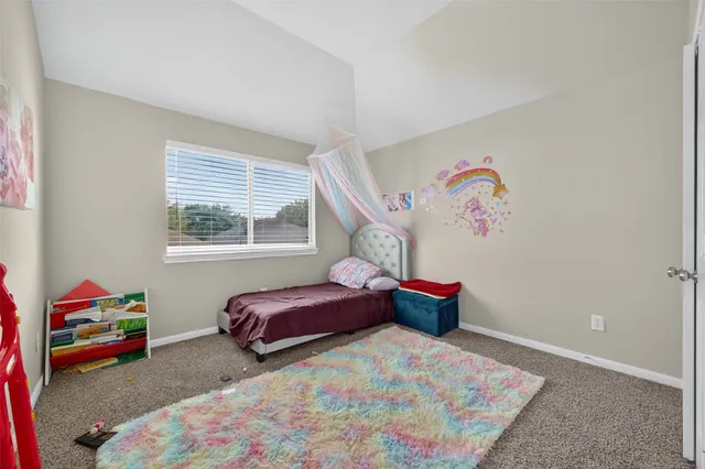 a bedroom with a bed and a painting on the wall