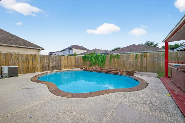 a view of a house with backyard swimming pool and sitting area