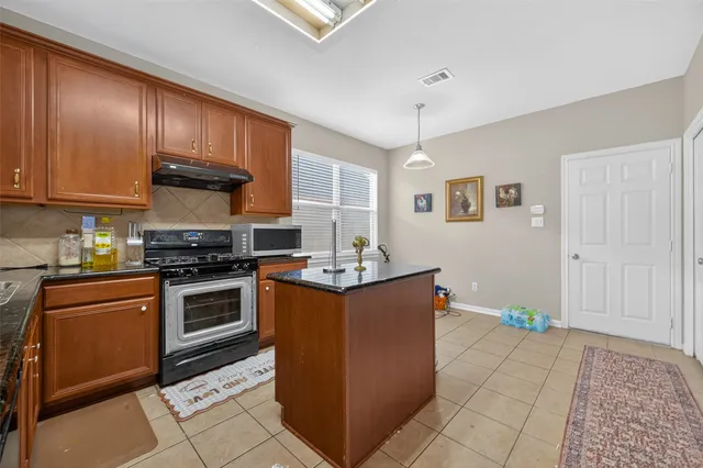 a kitchen with stainless steel appliances granite countertop a stove a sink dishwasher and a refrigerator