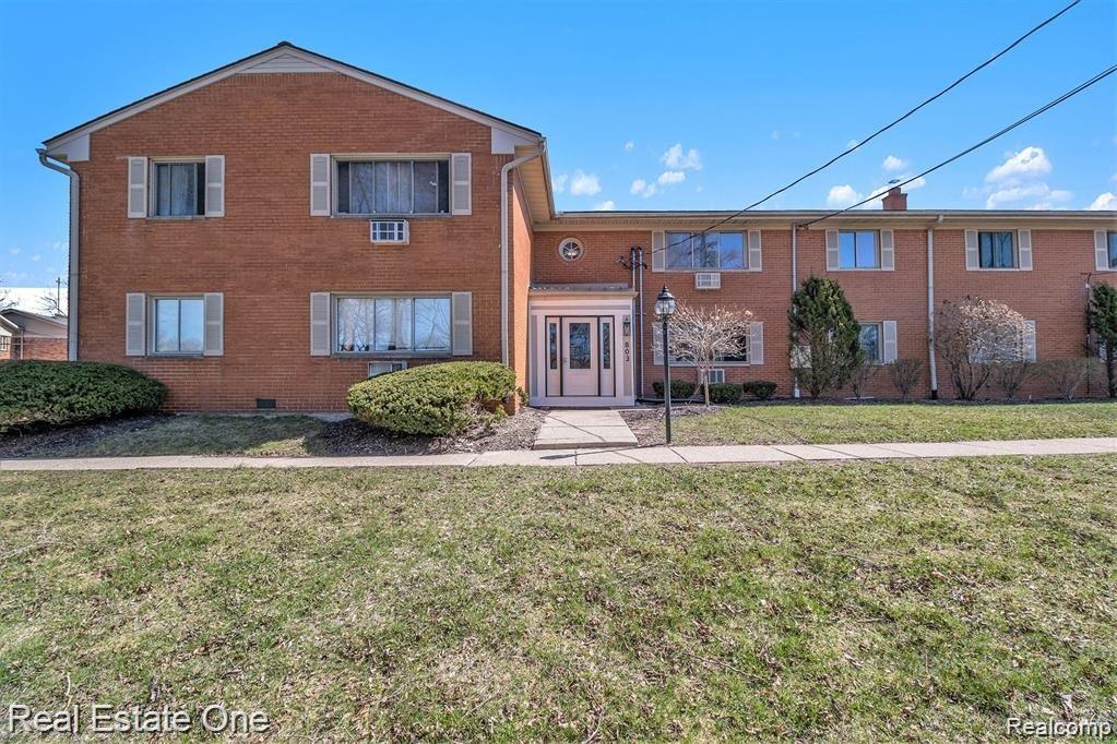 803 Plate Street, Unit 104 Rochester, MI 48307 - Photo 14 of 14 Brick facade multi-unit residential building featuring a central entrance with a decorative light fixture