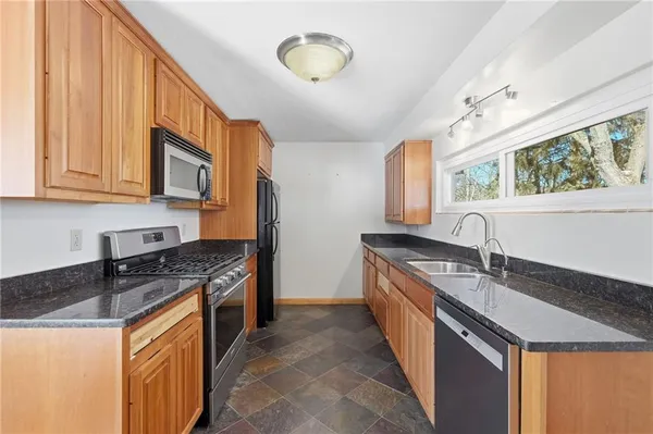 a kitchen with stainless steel appliances granite countertop a sink stove and cabinets