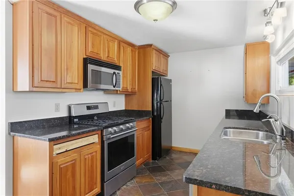 a kitchen with stainless steel appliances granite countertop a sink stove and refrigerator