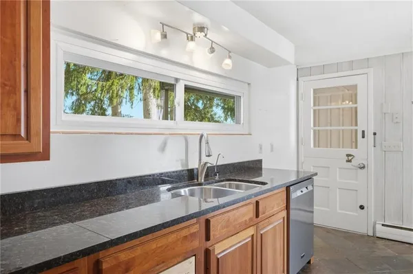 a kitchen with stainless steel appliances granite countertop a sink a stove and cabinets