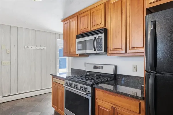 a kitchen with granite countertop cabinets stainless steel appliances and a counter space