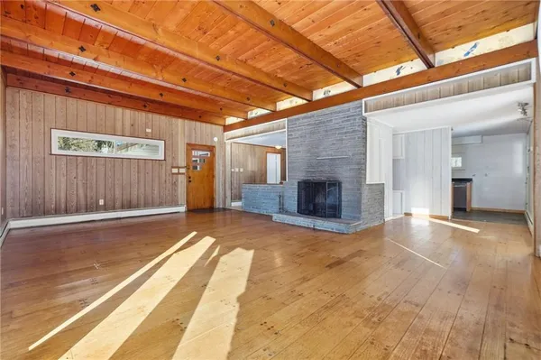 a view of empty room with wooden floor and fireplace