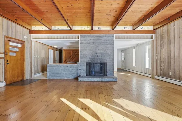 a view of empty room with wooden floor and fireplace