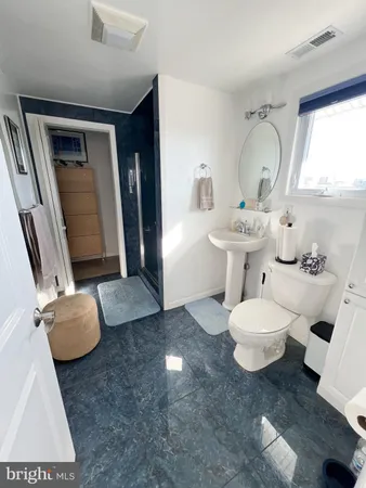 a bathroom with a toilet sink a mirror and vanity