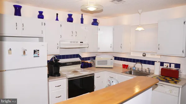 a kitchen with stainless steel appliances granite countertop a sink stove and white cabinets