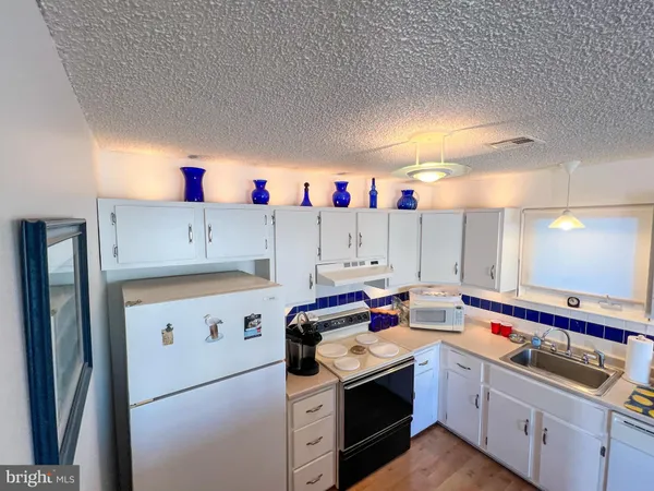 a kitchen that has a lot of cabinets in it and wooden floor