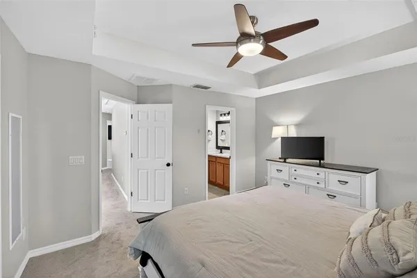 a bedroom with a bed and a flat tv screen on the dresser