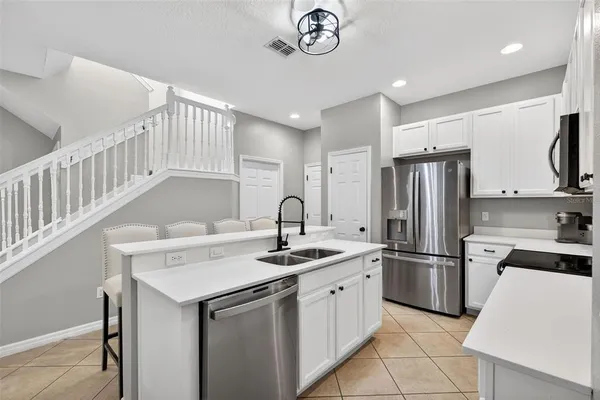 a kitchen that has a sink cabinets and stainless steel appliances