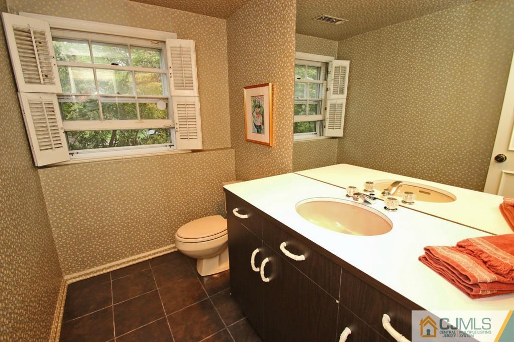 32 Clive Hills Road Edison, NJ 08820 - Photo 14 of 25 a bathroom with a sink a toilet and a mirror