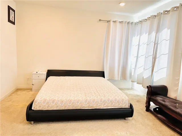 a bedroom with a bed couch and a window