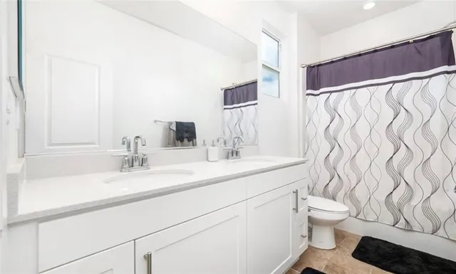 a bathroom with a granite countertop sink a toilet and a mirror