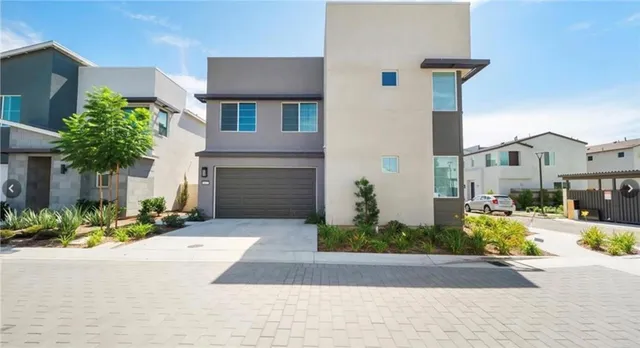 a front view of a house with a yard and potted plants