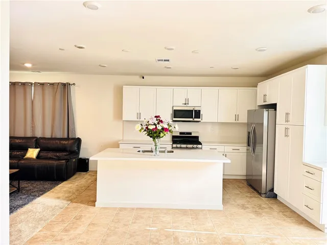 a kitchen with kitchen island a stove sink and refrigerator