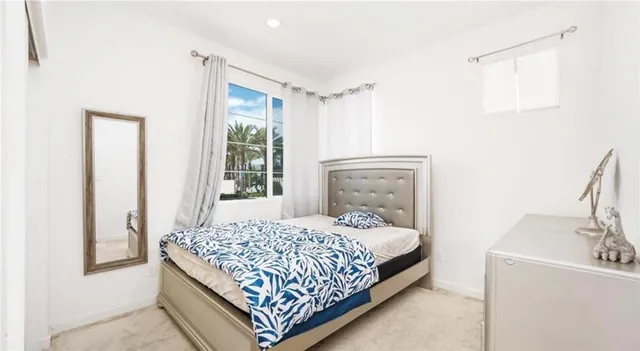 a bedroom with a bed lamp and a window