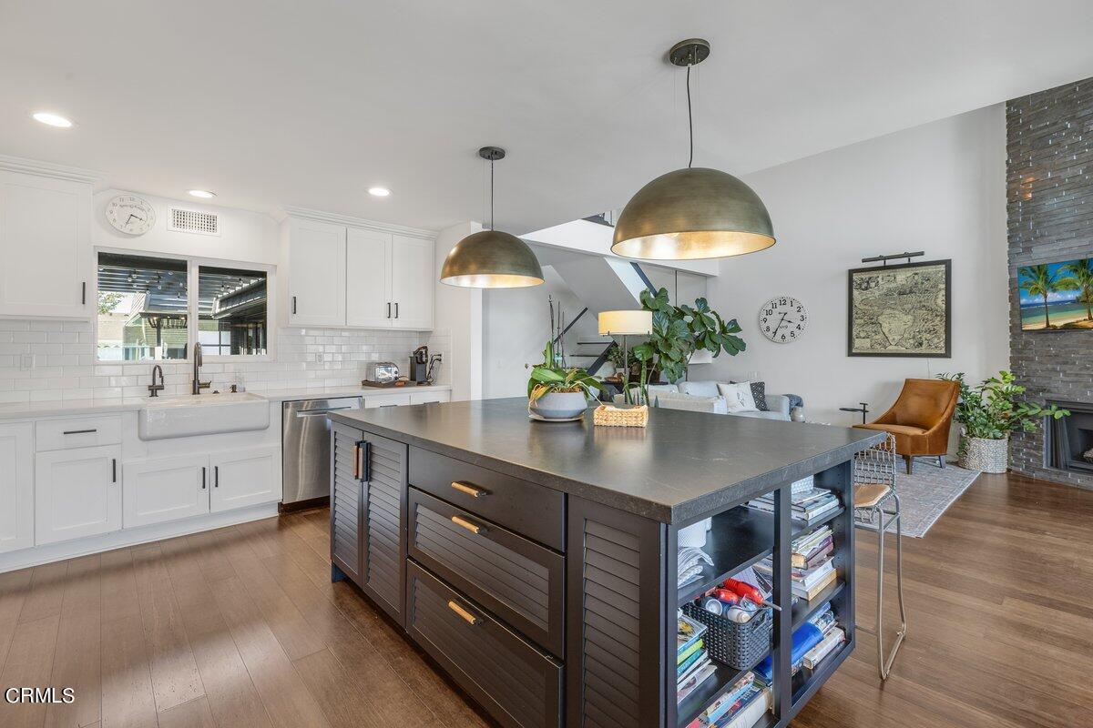 4612 Falkirk Bay Oxnard, CA 93035 - Photo 12 of 39 a kitchen with stainless steel appliances granite countertop a stove a sink dishwasher and a dining table with wooden floor