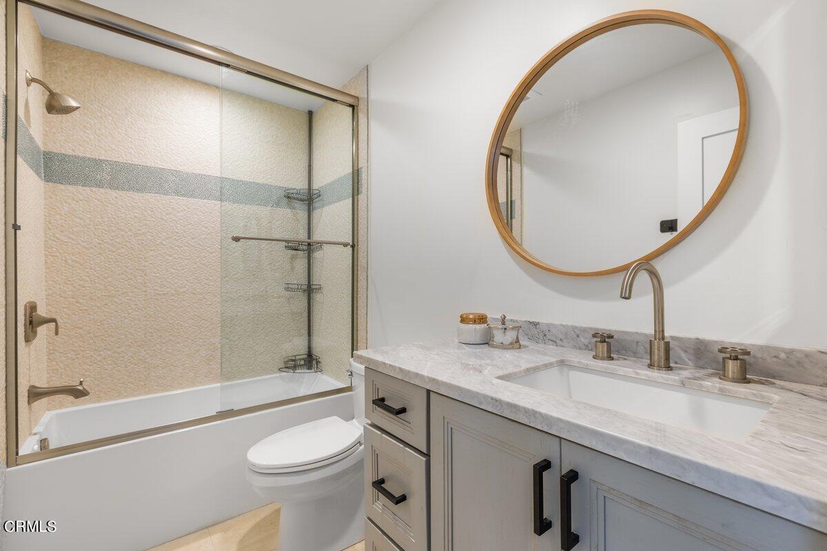 4612 Falkirk Bay Oxnard, CA 93035 - Photo 33 of 39 a bathroom with a granite countertop toilet a sink and a mirror